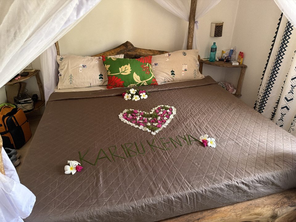 Scritta Karibu Kenya con fiori sul letto