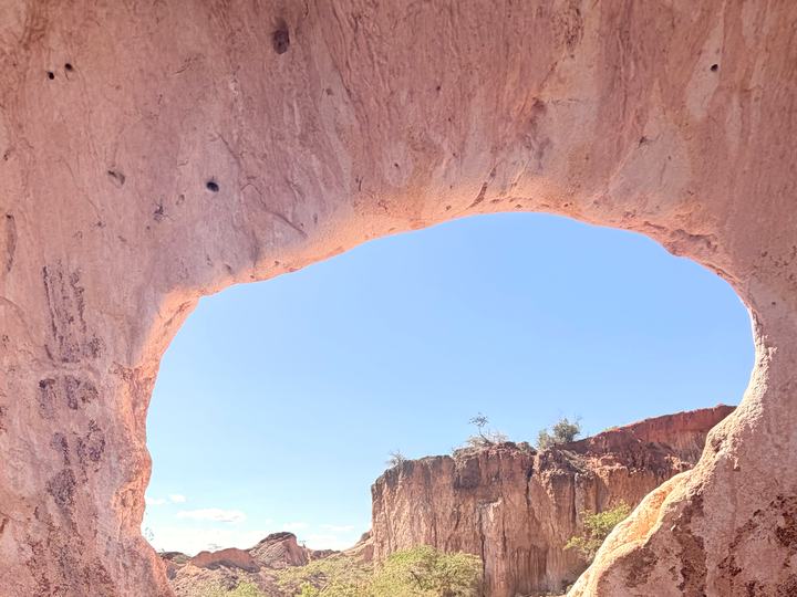 Finestra naturale nell'arenaria rossa affacciata sul canyon di Marafa