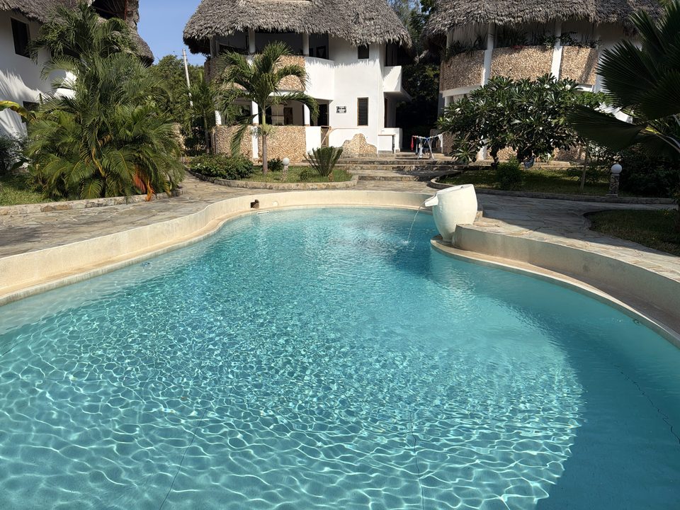 Piscina con fontana e giardino tropicale